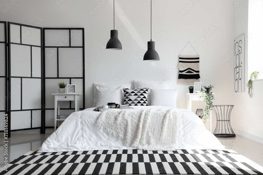 Wall mural Cozy bed with white blanket and pillows in interior of stylish bedroom