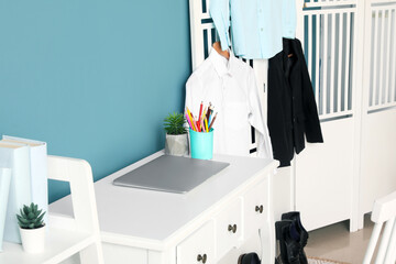 Modern laptop on table and school uniform in children's room, closeup