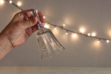 Glass bell in the hand of a woman in an intimate festive lighting - obrazy, fototapety, plakaty