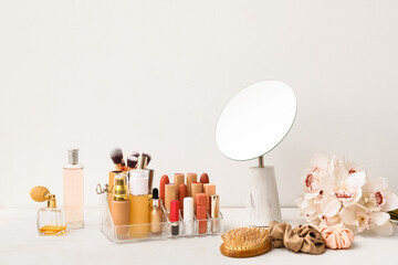 Different decorative cosmetics and mirror on white table