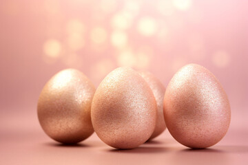 Softly Lit Sparkle-Dusted Easter Eggs on a Glittering Surface with Golden Bokeh Lights in the Background. Copy space