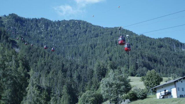 Gondolas coming down a ski hill in the summer. Wolkenstein, Italy
