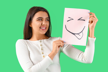 Young woman with paper smile on green background