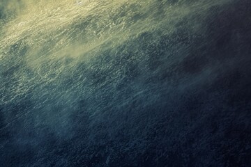 dynamic texture of a rough sea from above, with the sunlight filtering through in golden hues...