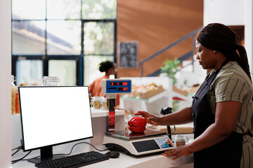 Vendor weighing organic sustainable produce on digital scale while computer displays isolated...