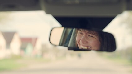 Beautiful young woman traveling by car, smiling, rejoicing, good mood. Young female driver in...