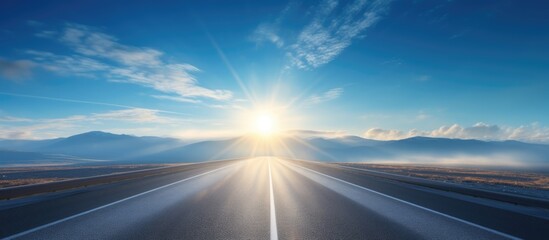 Hazy road and blue sky with a bright sun - Powered by Adobe