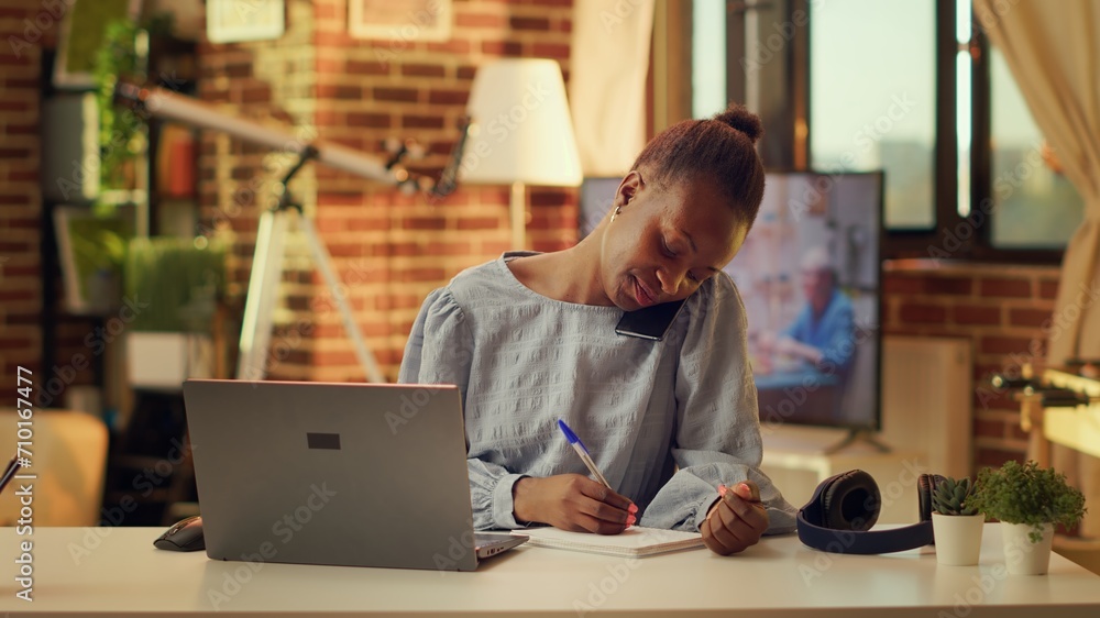 Aufkleber freelancer writing notes from phone call at home office, using handwriting to have list of informati