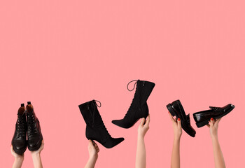Female hands holding different shoes on pink background