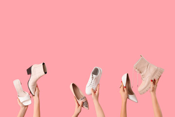 Female hands holding different shoes on pink background