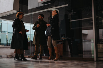 Business partners collaborating on a project in a city area at outdoor meeting on a rainy and cloudy day.