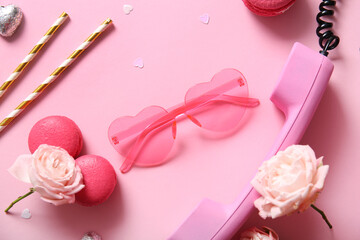 Pink sunglasses with retro telephone, macarons and roses on color background. Valentine's Day concept