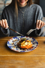 Delicious breakfast, brunch, lunch. A girl happily eats toast in a restaurant.