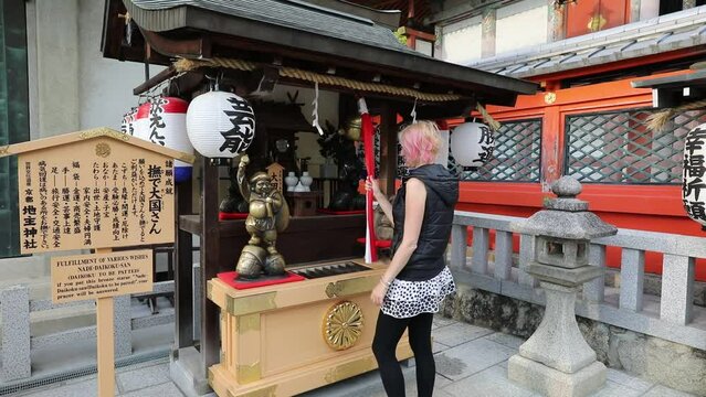 Woman prays at Jishu Jinja Shrine, located above main hall of Kiyomizudera, is a temple dedicated to Okuninushi god of love. Jishu Shrine is revered as Cupid of Japan and on hilltop of Kyoto in Japan.