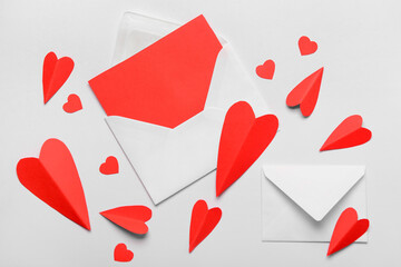Envelopes with blank card and red paper hearts on white background. Valentine's Day celebration