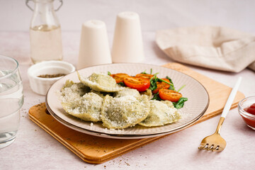 Plate of tasty ravioli with tomatoes and cheese on white background