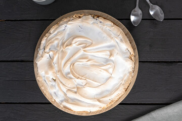 Meringue cake with rhubarb on a brown table