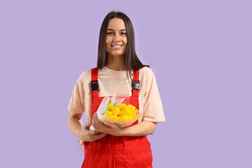 Female worker with bouquet of tulips on lilac background. International Women's Day celebration