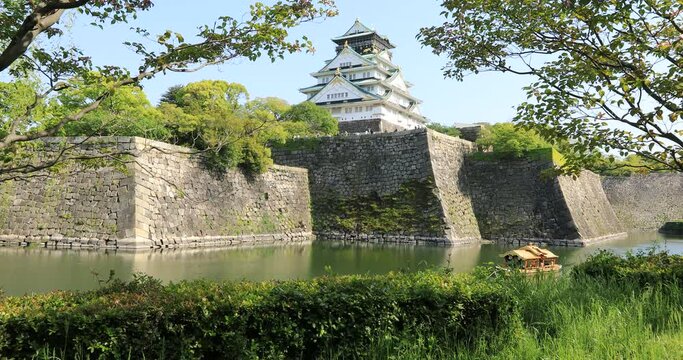 Tourist boats along the moat and the wall of Osaka Castle in Osaka Castle Park. Osaka city, Japan.