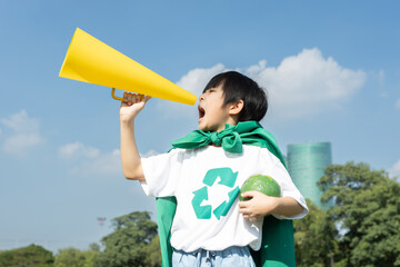 Young superhero boy with recycle symbol and cape make announcement with speaker on environmental...