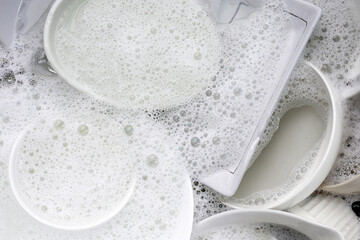 Dish washing, Dirty dishes soaking in kitchen sink.