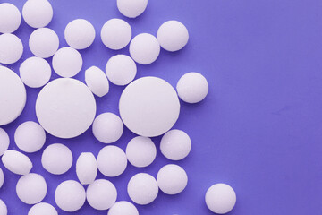 White mothballs on purple background.