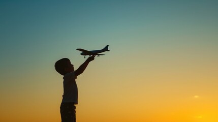 Silhouette of boy playing with airplane toy against clear sky