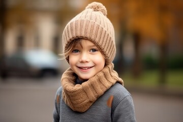 Portrait of a cute little girl wearing a warm hat and scarf outdoors