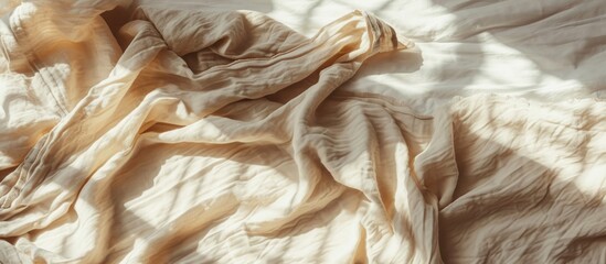 Crumpled tan bed blanket with sunlight shadows, styled flat lay mock up.