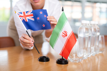 Little flag of Iran on table with bottles of water and flag of Australia put next to it by positive...