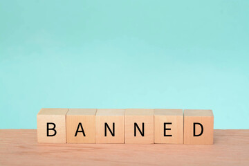 Wooden block with text BANNED. A ban refers to a formal or official prohibition or restriction on a...