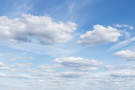 Beautiful light blue sky with many white cirrus and fluffy clouds in sunlight, background texture, heaven