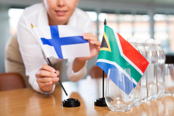 Little flag of South Africa on table with bottles of water and flag of Finland put next to it by...