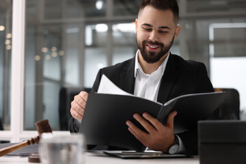 Smiling lawyer with folder in office, space for text