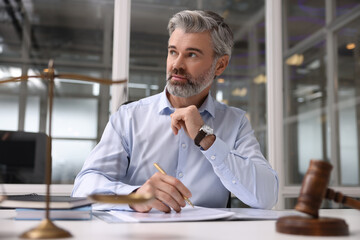 Portrait of handsome lawyer at table in office
