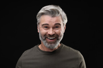 Obraz premium Personality concept. Portrait of happy man on black background