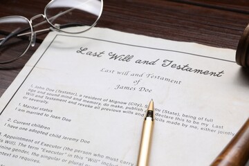 Last Will and Testament with glasses and pen on wooden table, closeup