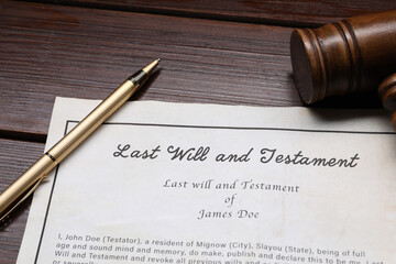 Last Will and Testament with gavel and pen on wooden table, closeup