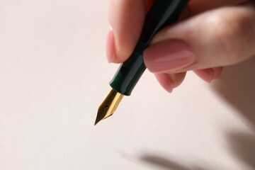 Woman writing with fountain pen, closeup view