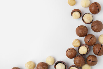 Tasty Macadamia nuts on white background, flat lay. Space for text