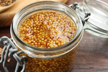 Whole grain mustard in jar on table, closeup