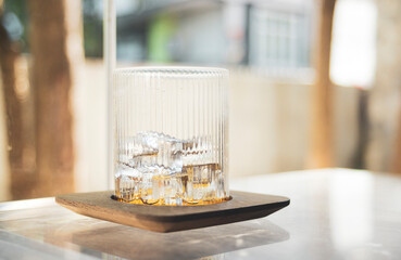 Glass with ice on table in coffee shop, stock photo