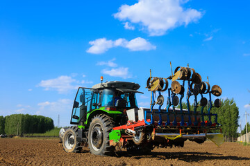 In spring, farmers use farm machinery to grow peanuts