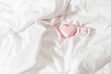 14 february lifestyle background, holiday date on calendar in bed, pink paper 3d heart and wooden...