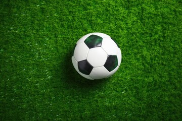 Fototapeta premium Top view of soccer ball on green artificial grass field