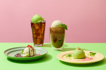 Front view of two plates with two ice cream balls decorated with chocolate sauce, strawberry sauce,...