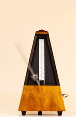 Metronome On Light Background With Blurred Arm Moving Fast