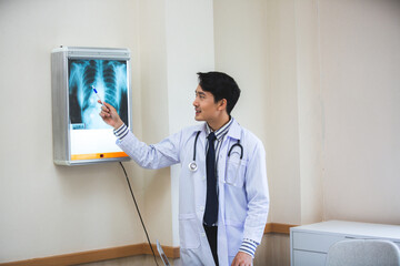 Expertise and professional Male doctor or physician show x-ray film result and explaining,...