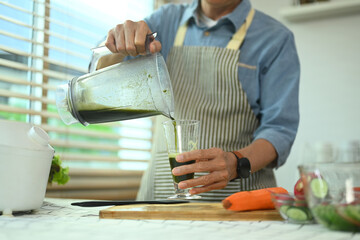 Cropped shot middle age man preparing a healthy detox drink in kitchen. Healthy eating concept