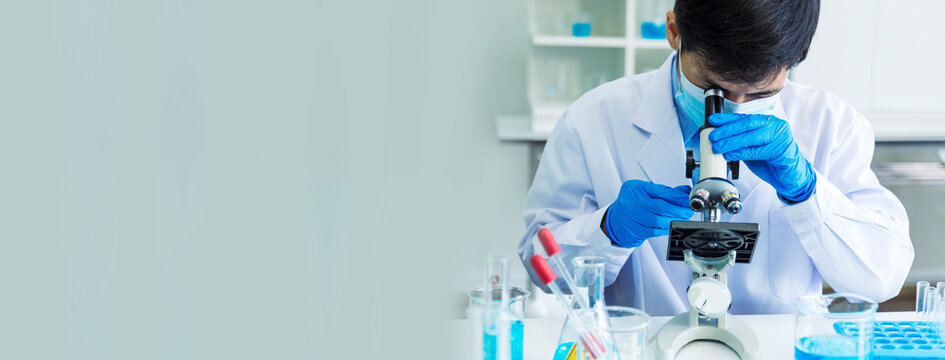Banner Scientist man look Microscope research in science laboratory. Banner Asian scientist use microbiology microscope in laboratory equipment chemistry lab. Biochemistry experiment with copy space